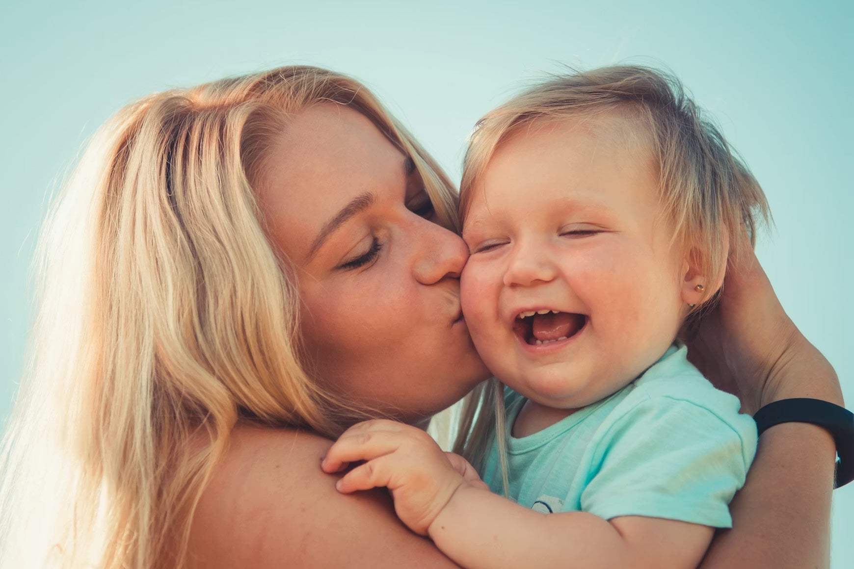 Moeder kust haar lachende baby